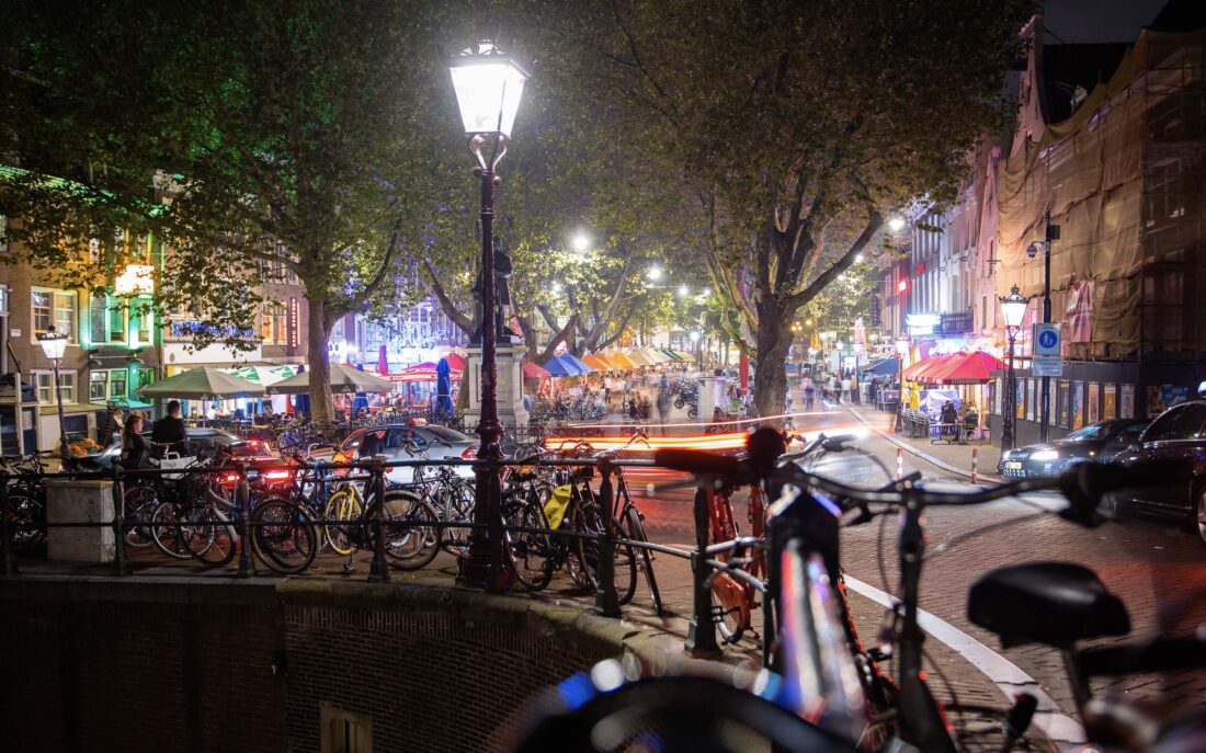 Canal-side street at night, bicycles in the foreground